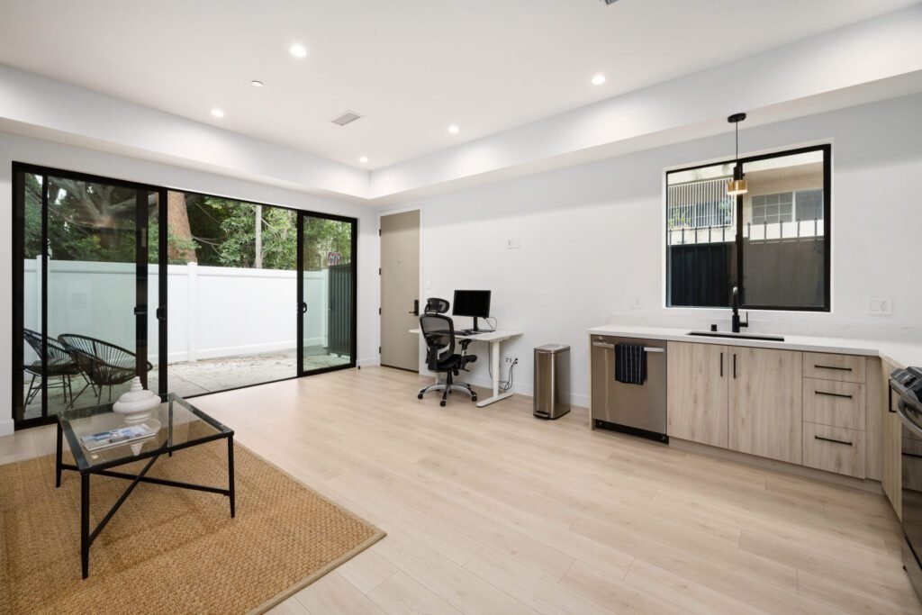 Modern open-layout ADU with light wood cabinets and sliding glass door