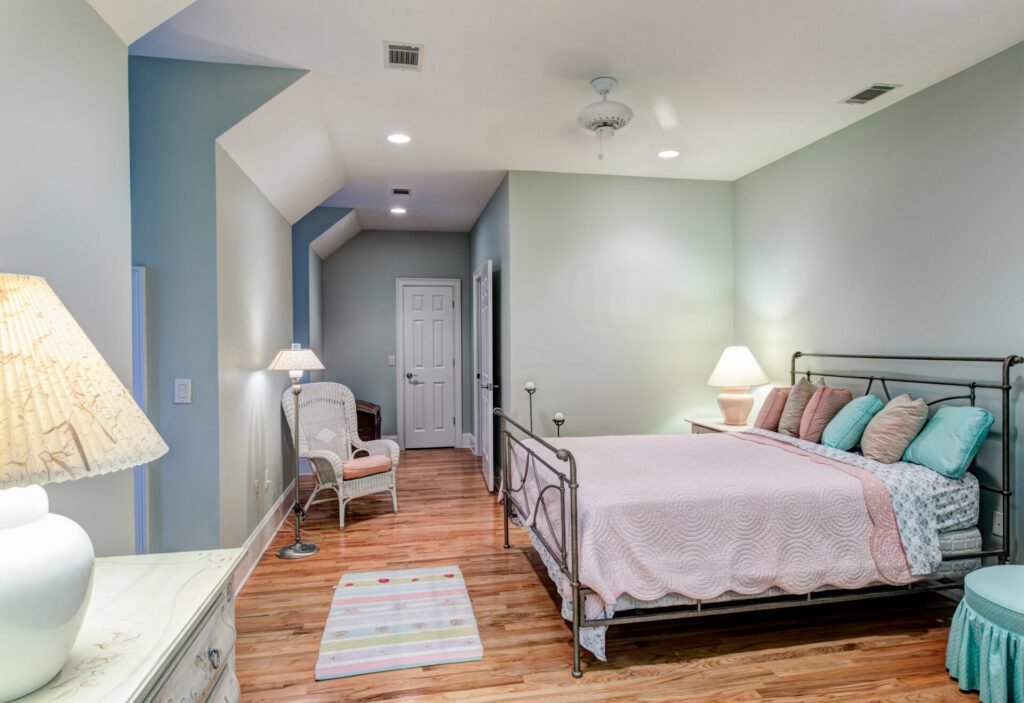 Cozy ADU interior with bed, chair, pastel tones, and wood floors