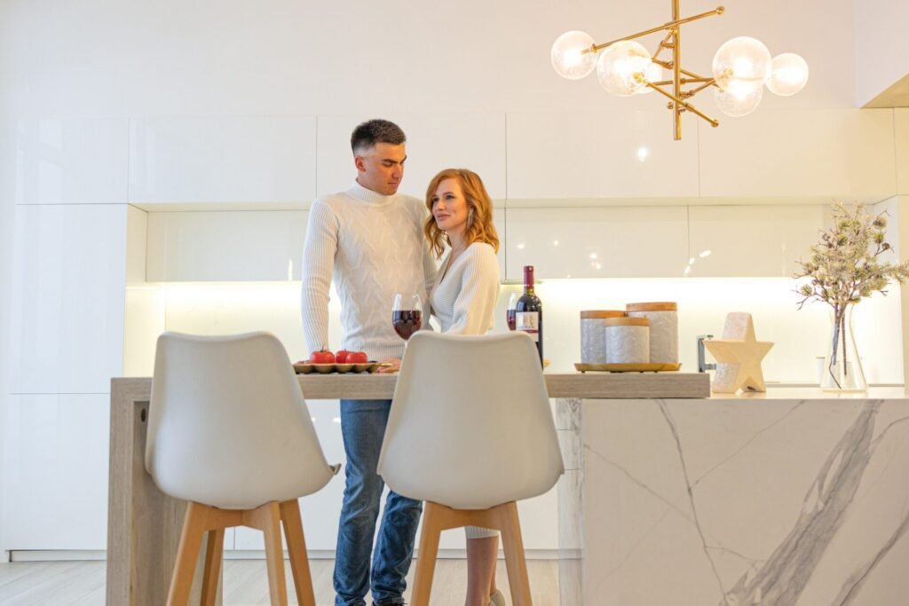 Young couple smiling and relaxing in their newly remodeled home with modern finishes.